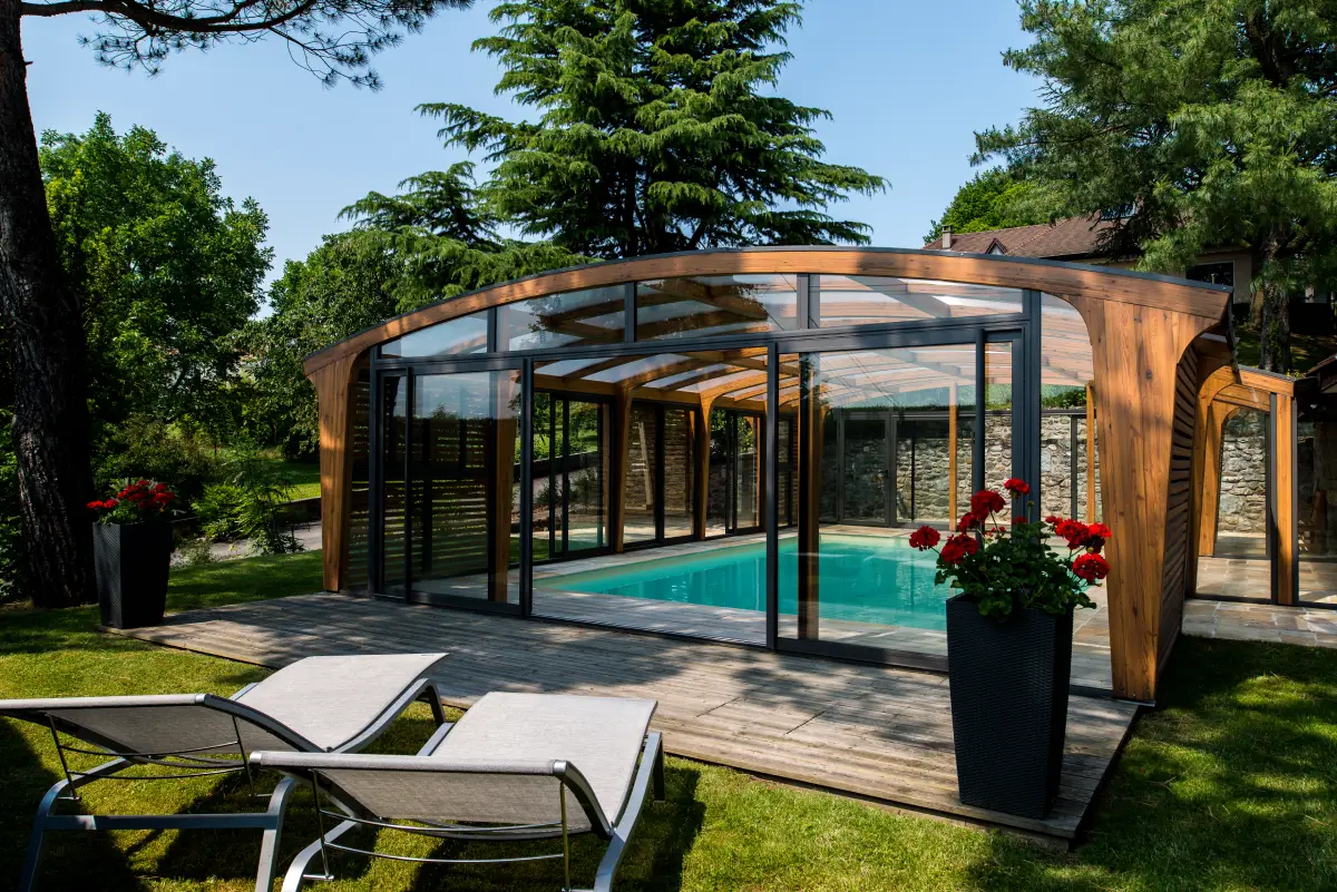 Grand abri de piscine en bois avec de nombreuses baies vitrées qui s'ouvrent