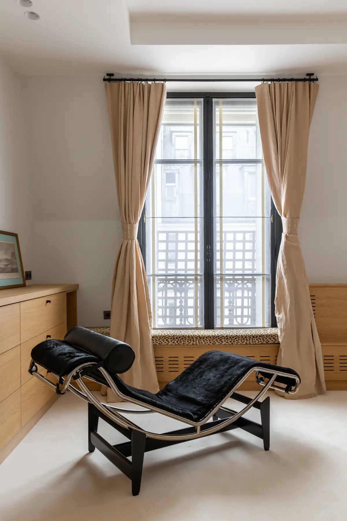 Cacher un radiateur dans un banc en bois sur mesure pour réchauffer l'atmosphère. Assise en tissu motif léopard et rideaux beiges