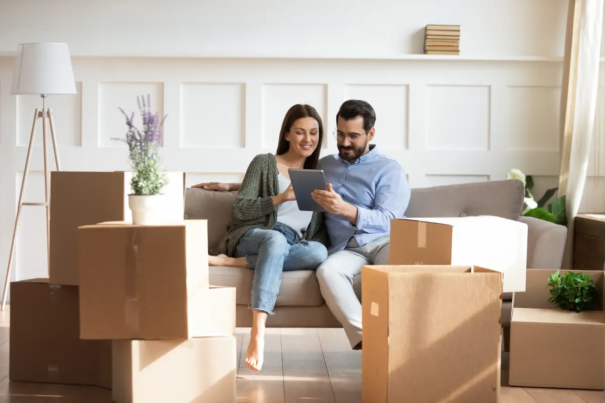 Cartons de déménagement dans un salon avec un couple