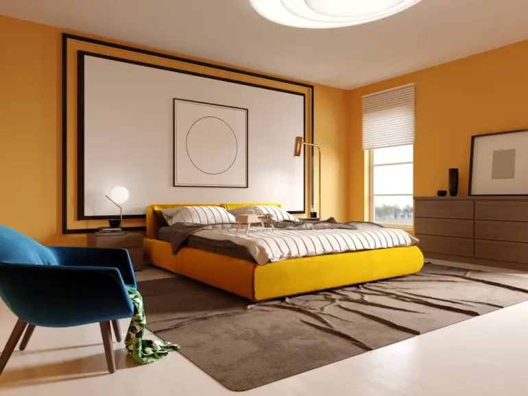 Chambre mur jaune moutarde et fauteuil bleu