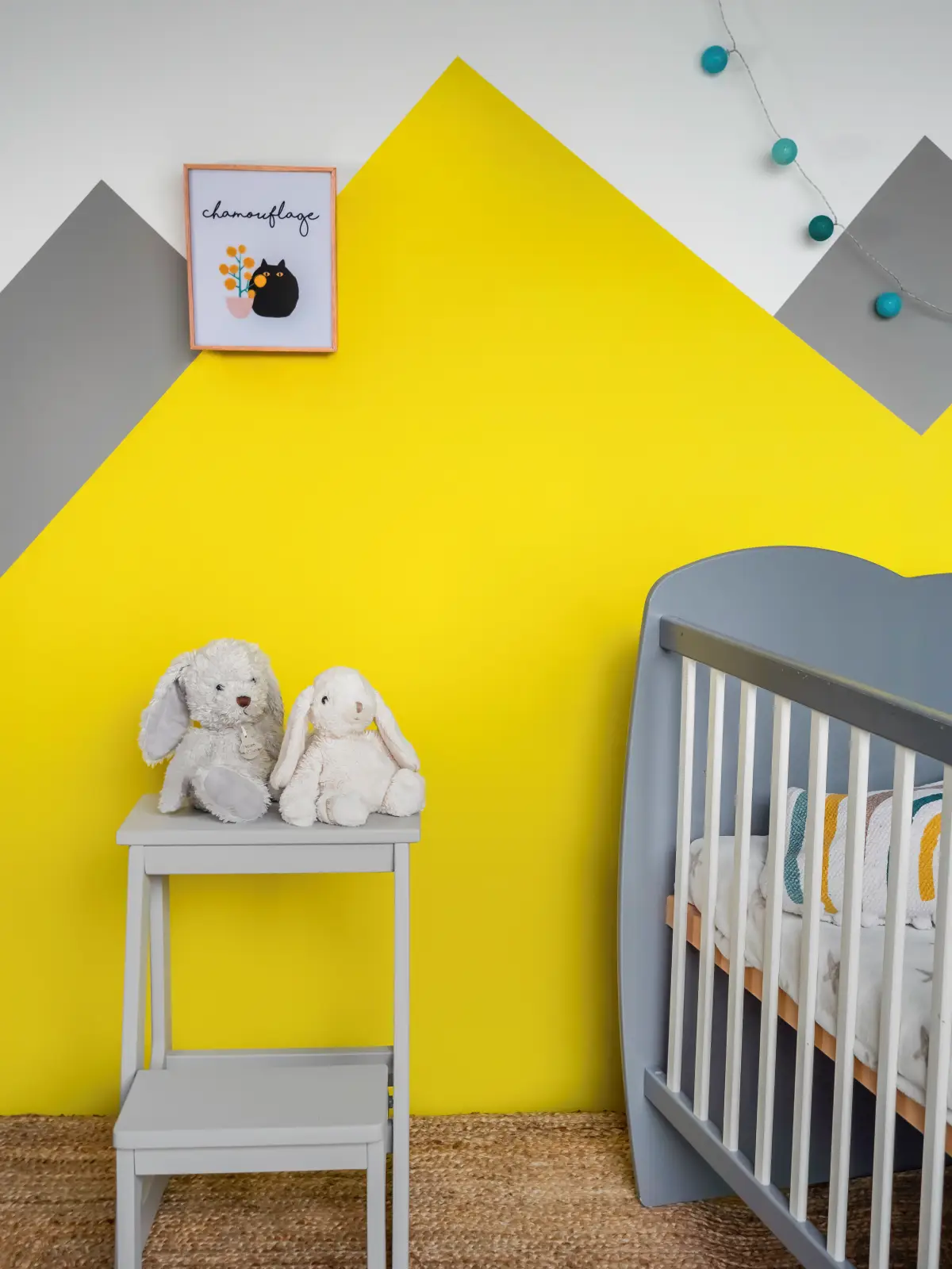 Fresque murale jaune et grise dans une chambre de bébé