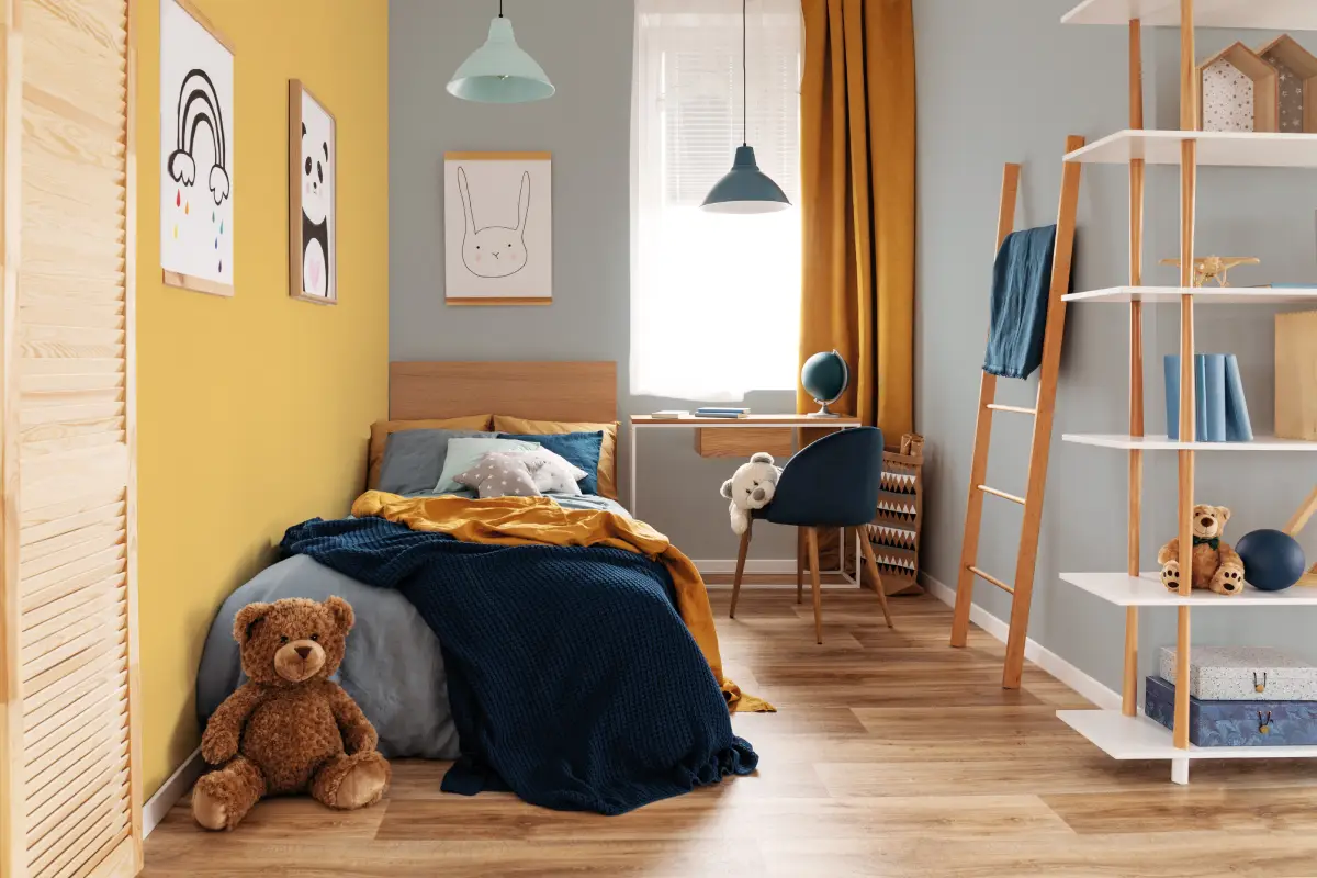 Chambre de garçon mur jaune, draps bleus et meubles en bois