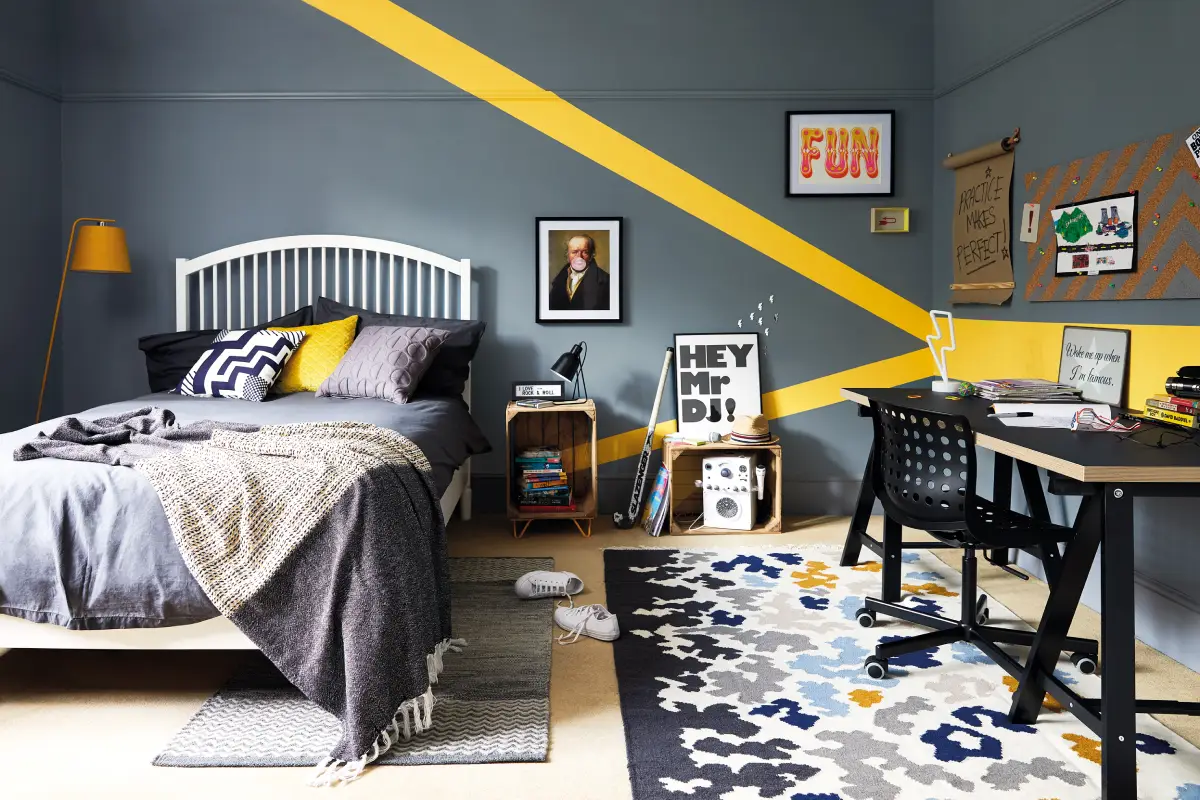 Chambre de garçon grise avec des pointes graphiques de jaune.
