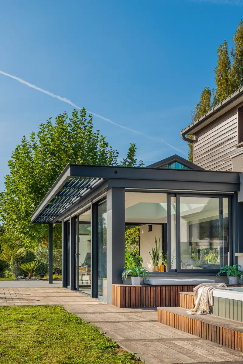 Véranda en aluminium grise, bain à remous sur la terrasse