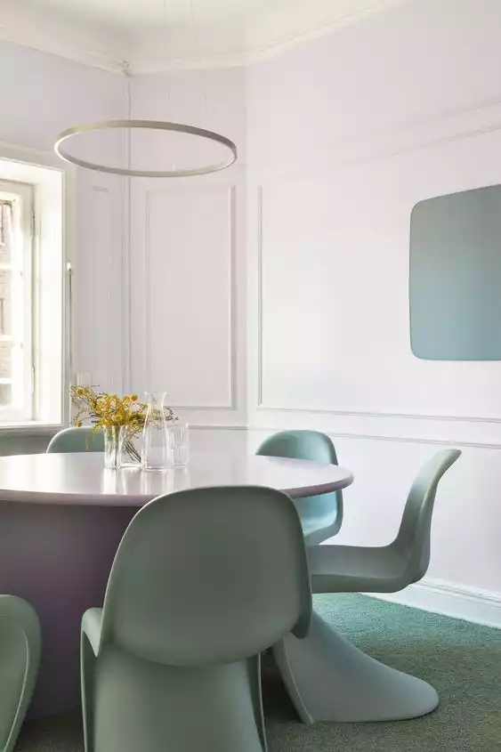 Chaise Panton vert pastel autour d'une table de salon