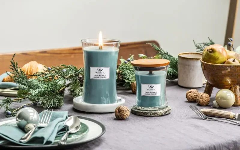 Bougies parfumées cocooning sur la table de Noël, cire bleue, mèche en bois