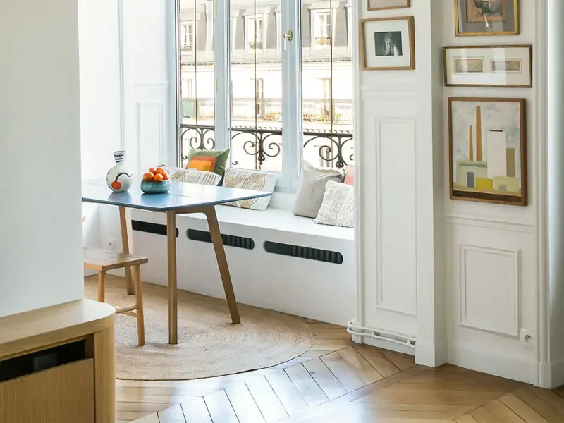 Radiateur caché dans un coffrage blanc faisant également office de banc.