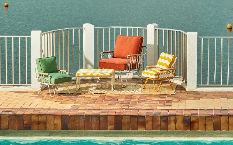 Collection Honoré x Monoprix 2025, fauteuils et table au bord de la mer, inspiration méditerranée
