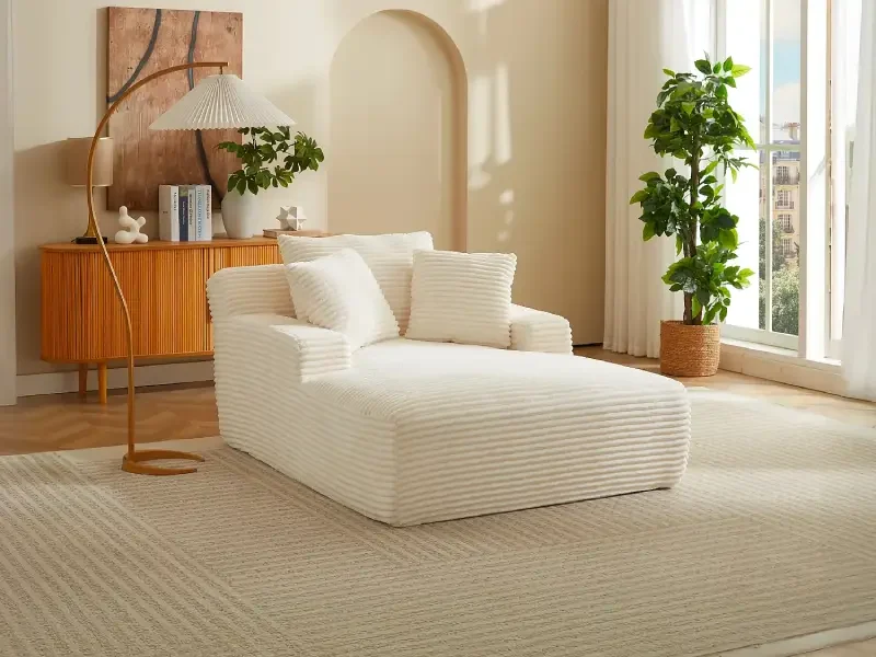 Méridienne en velours côtelé grosses côtes beige dans un salon, tapis crème, lampadaire