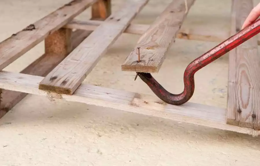 Démonter les palettes de bois à l'aide d'un pied de biche