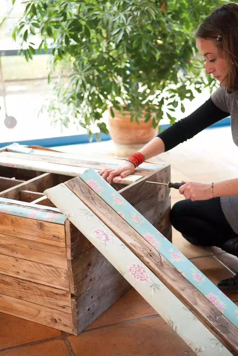 Visser les lattes décorées à l'arrière du meuble en bois de palettes