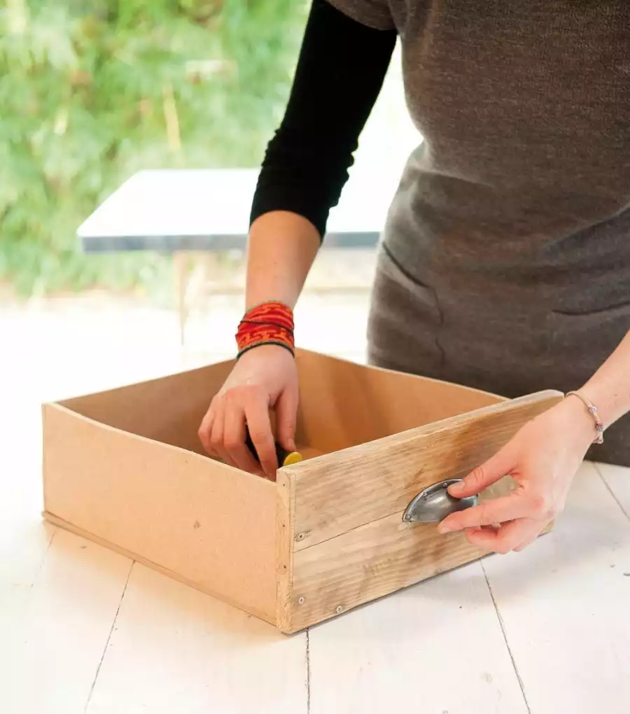 Fixer les poignées des tiroirs du meuble en bois de palettes