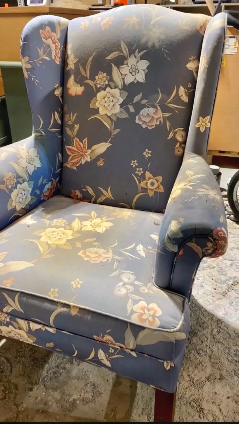 Vieux fauteuil bleu à fleurs en tissu