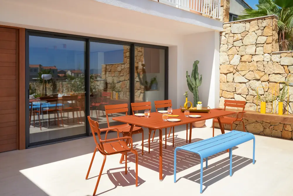 Table de jardin et chaises orange, banc bleu en aluminium