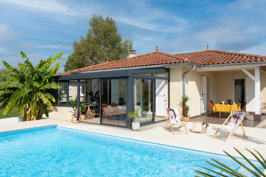 Installer une véranda en aluminium grise, terrasse et piscine