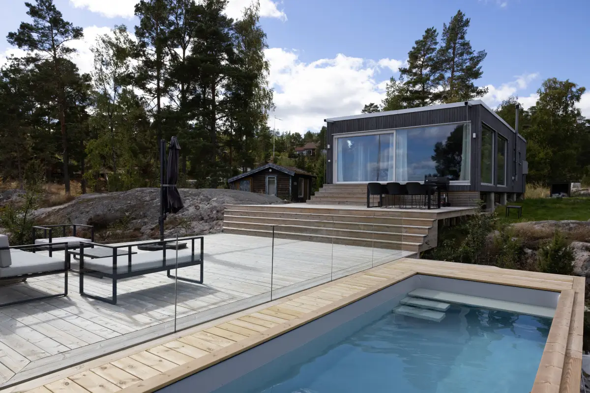 Vue sur terrasse en bois à différents niveaux et espace piscine délimité par une clôture, inspiration pour aménager ses espaces extérieurs